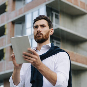 Man with a tablet inspecting a residential building